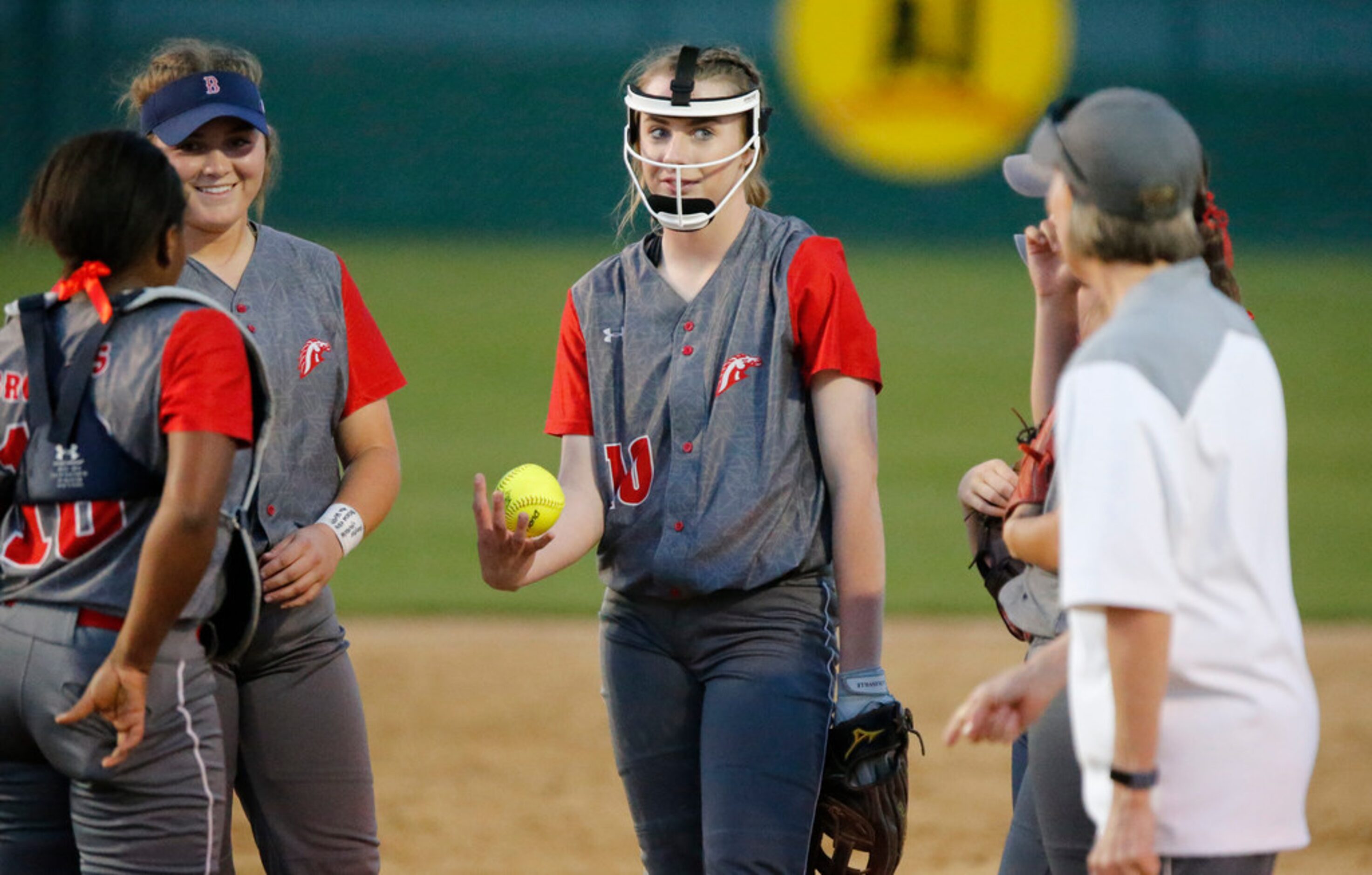 McKinney Boyd High School pitcher Kinsey Kackley (10) has a meeting on the mound with her...