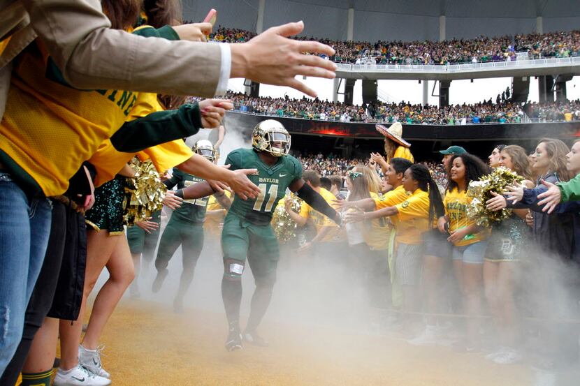 Baylor Bears linebacker Taylor Young (11) runs through the smoke during introductions before...