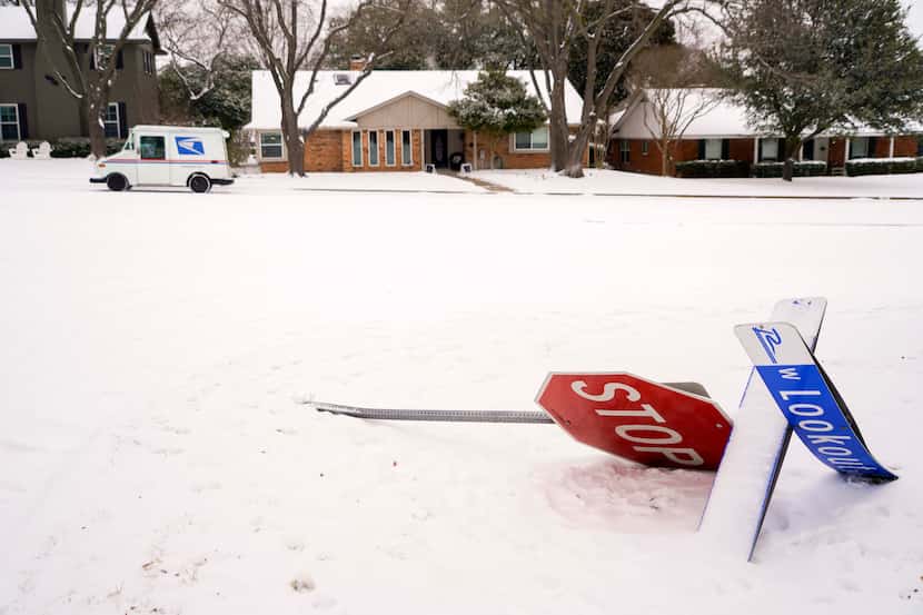 A knocked down stop sign is pictured in Richardson Wednesday after a second round of snow...
