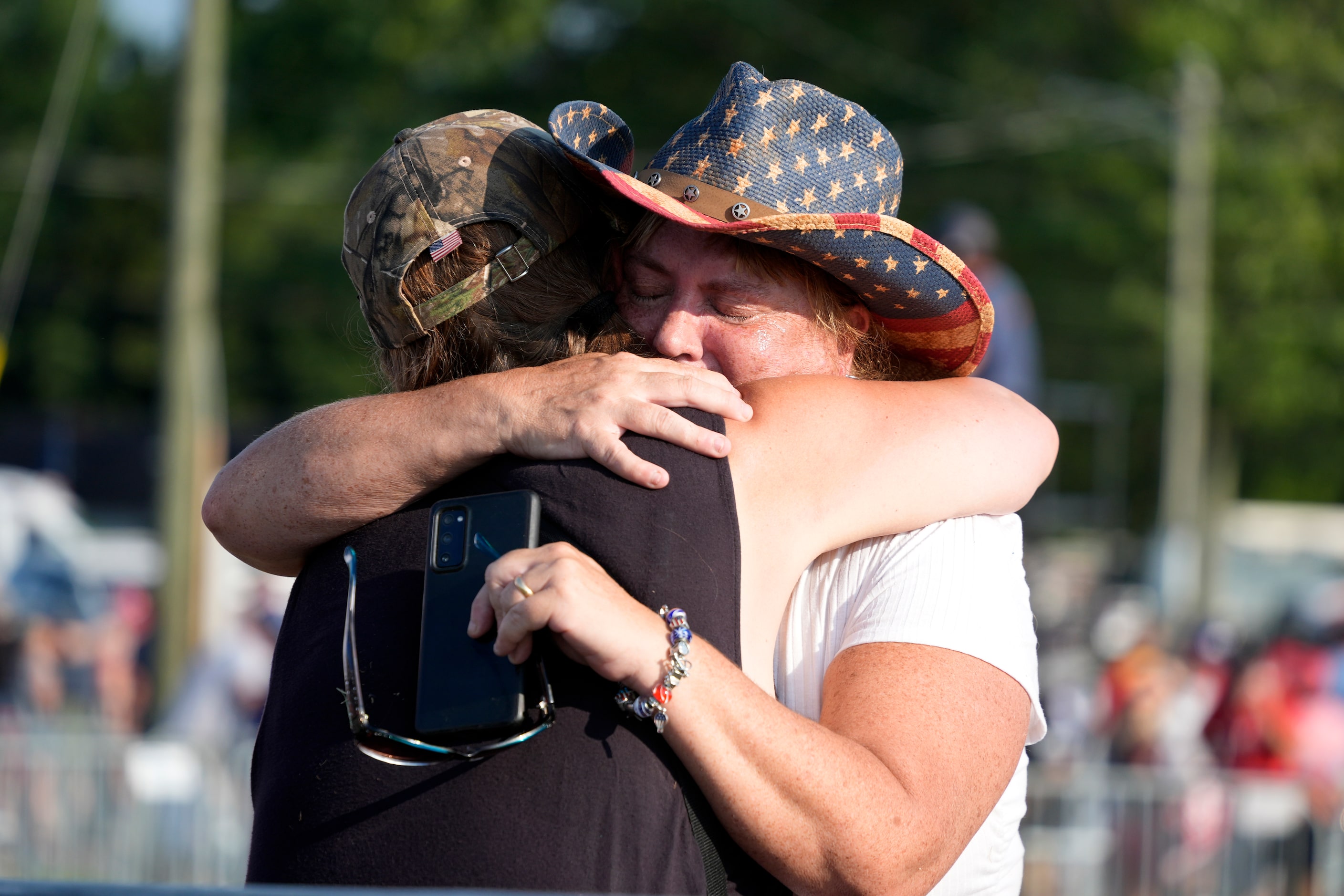 People hug after Republican presidential candidate former President Donald Trump was helped...