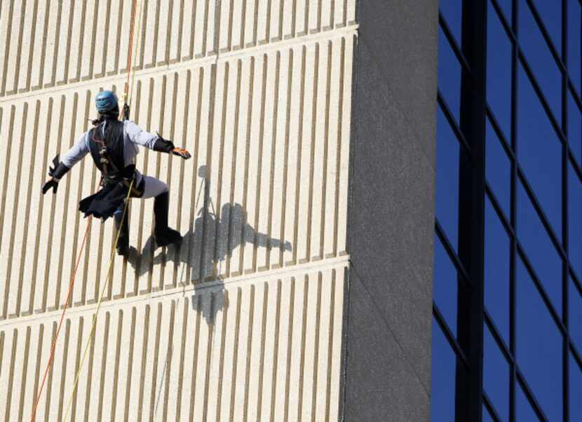 Clayton Dean, dressed as Batman, rappelled down the side of the InterContinental Dallas...
