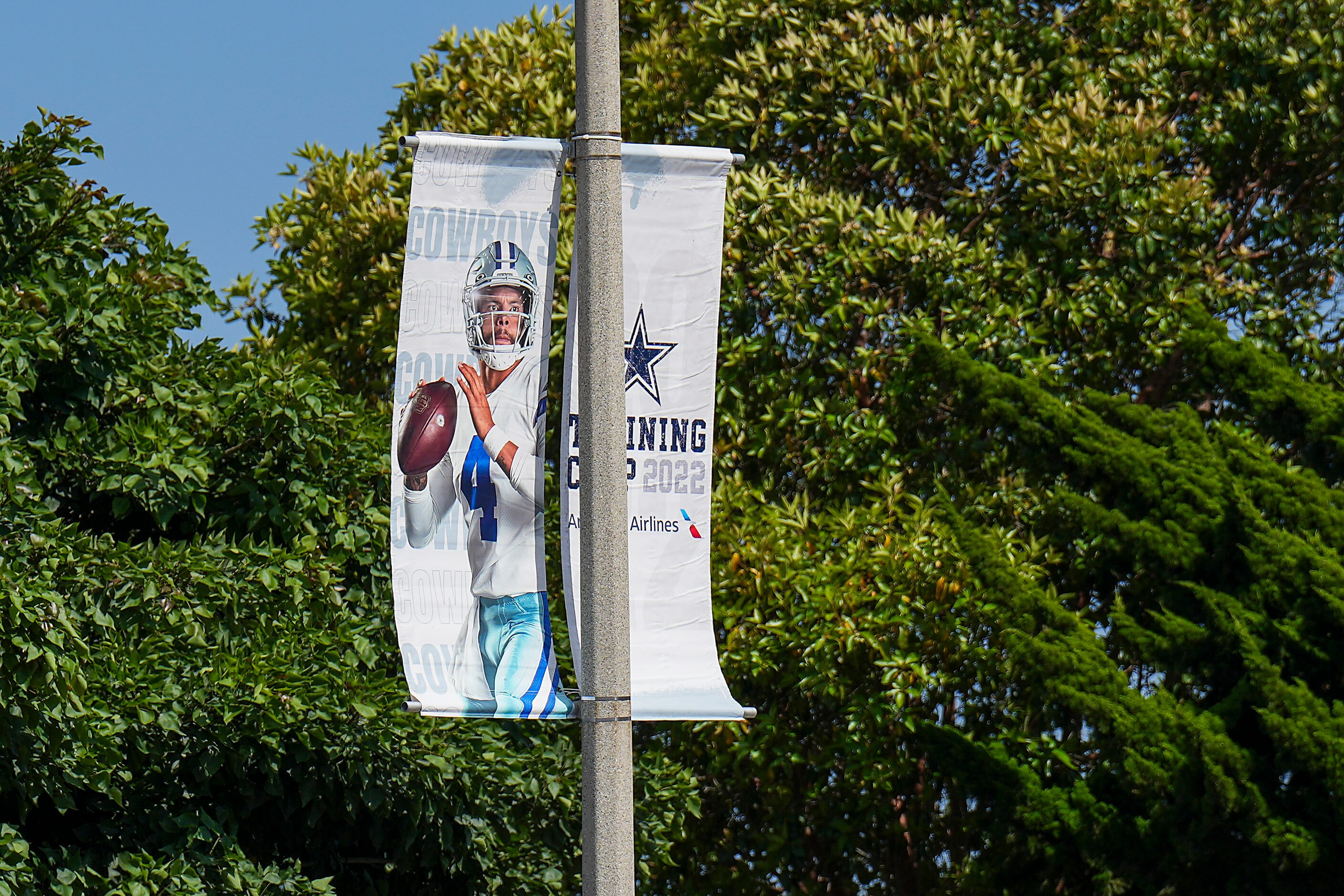 Banners featuring Dallas Cowboys quarterback Dak Prescott promote the team’s training camp...