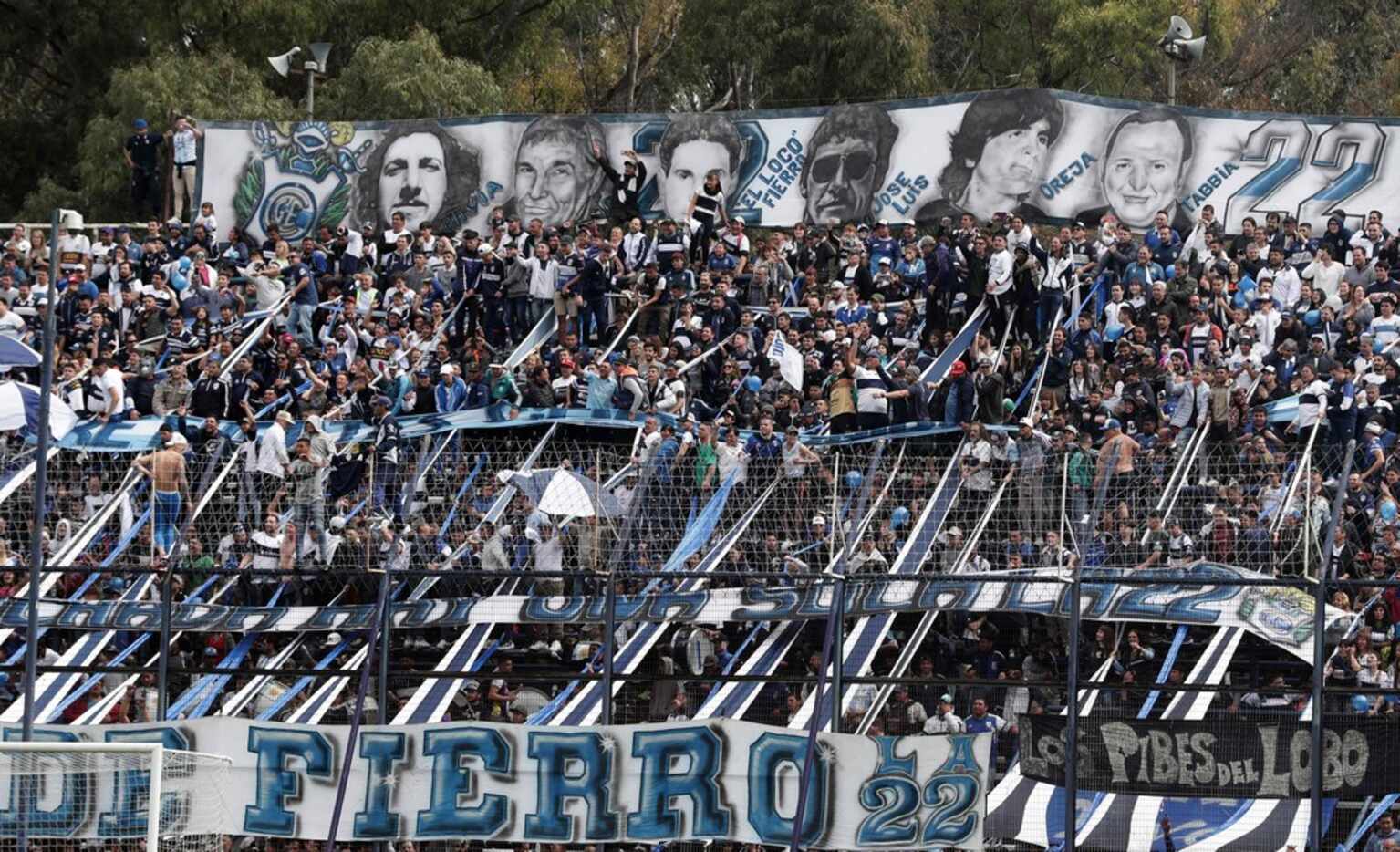 Supporters of Gimnasia cheer for their team during the first training session of the team...