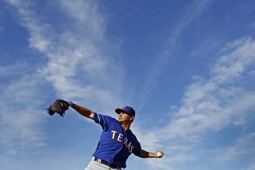 Texas pitcher Martin Perez warms up before morning practice during Texas Rangers baseball...