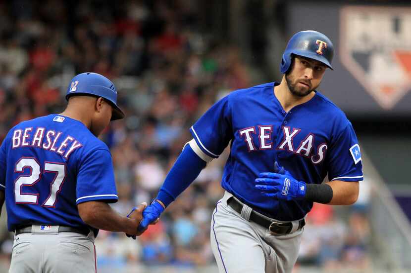 Texas Rangers Joey Gallo (13) is congratulated by third base coach Tony Beasley (27) after...