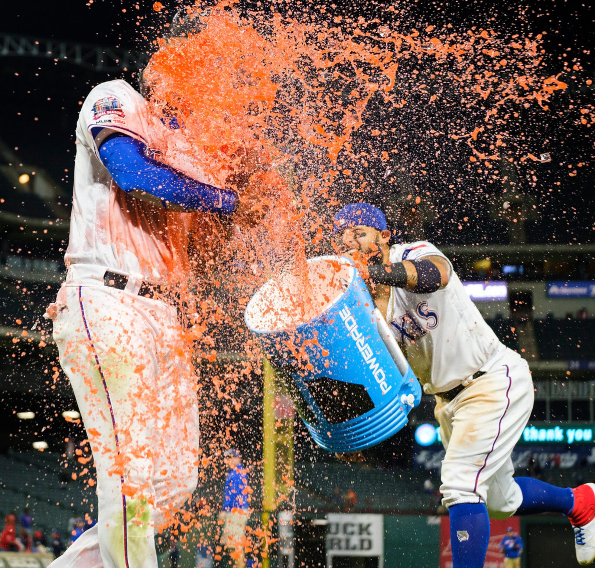 Texas Rangers shortstop Elvis Andrus is doused with sports drink by teammate Rougned Odor...