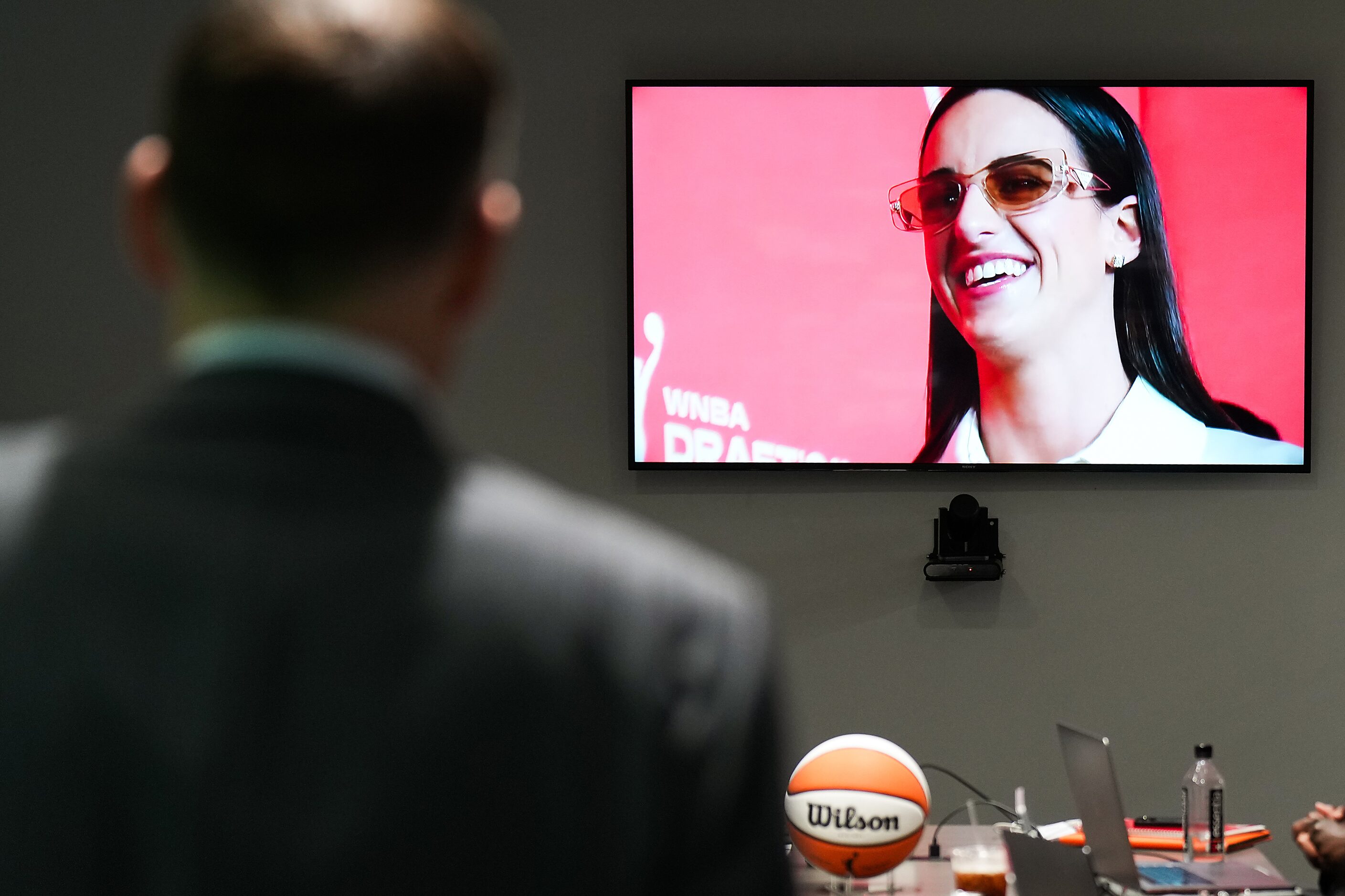 Dallas Wings President and CEO Greg Bibb watches coverage of Caitlin Clark, the first pick...