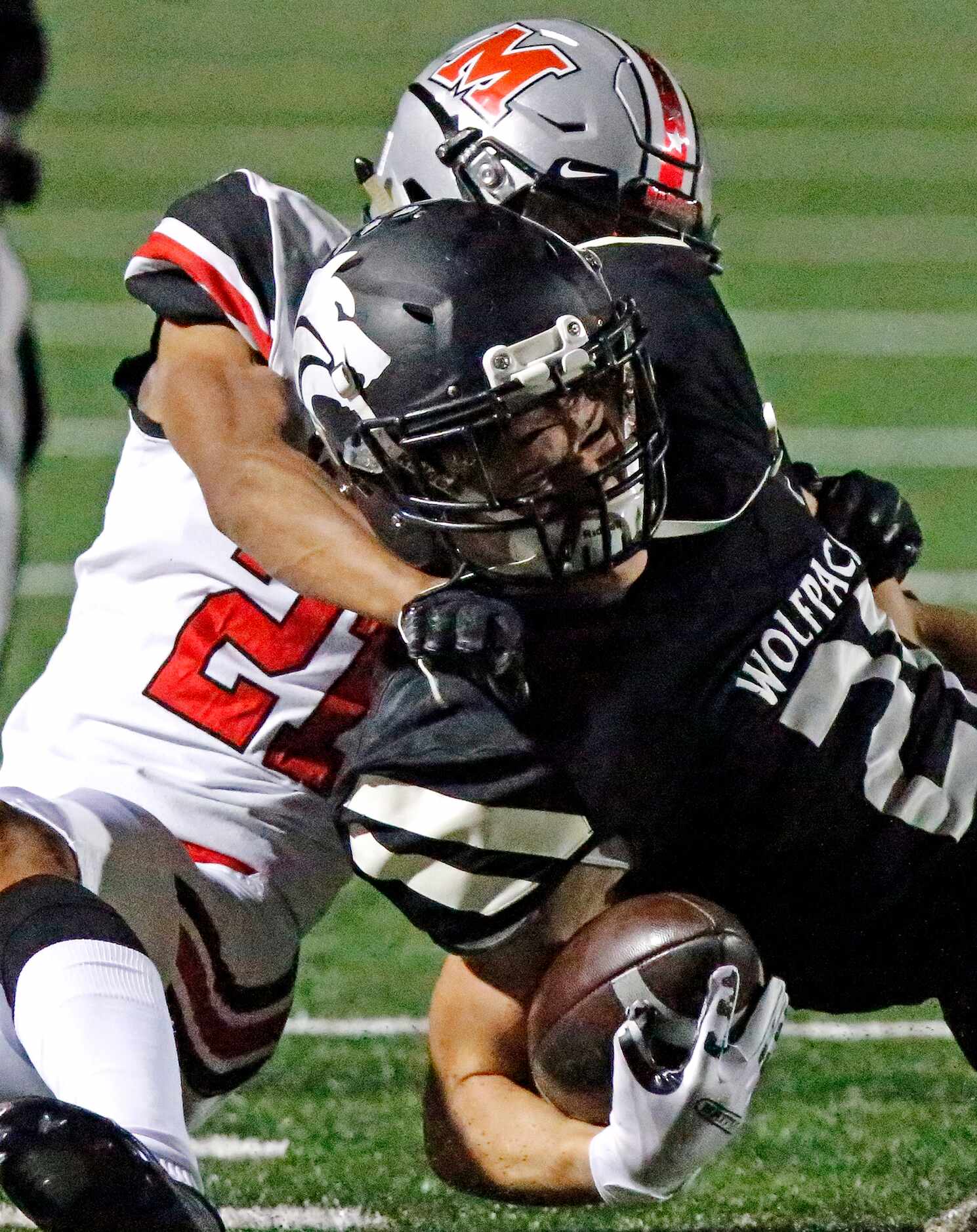 Plano West High School running back Dermot White (21) is tackled by Flower Mound Marcus High...
