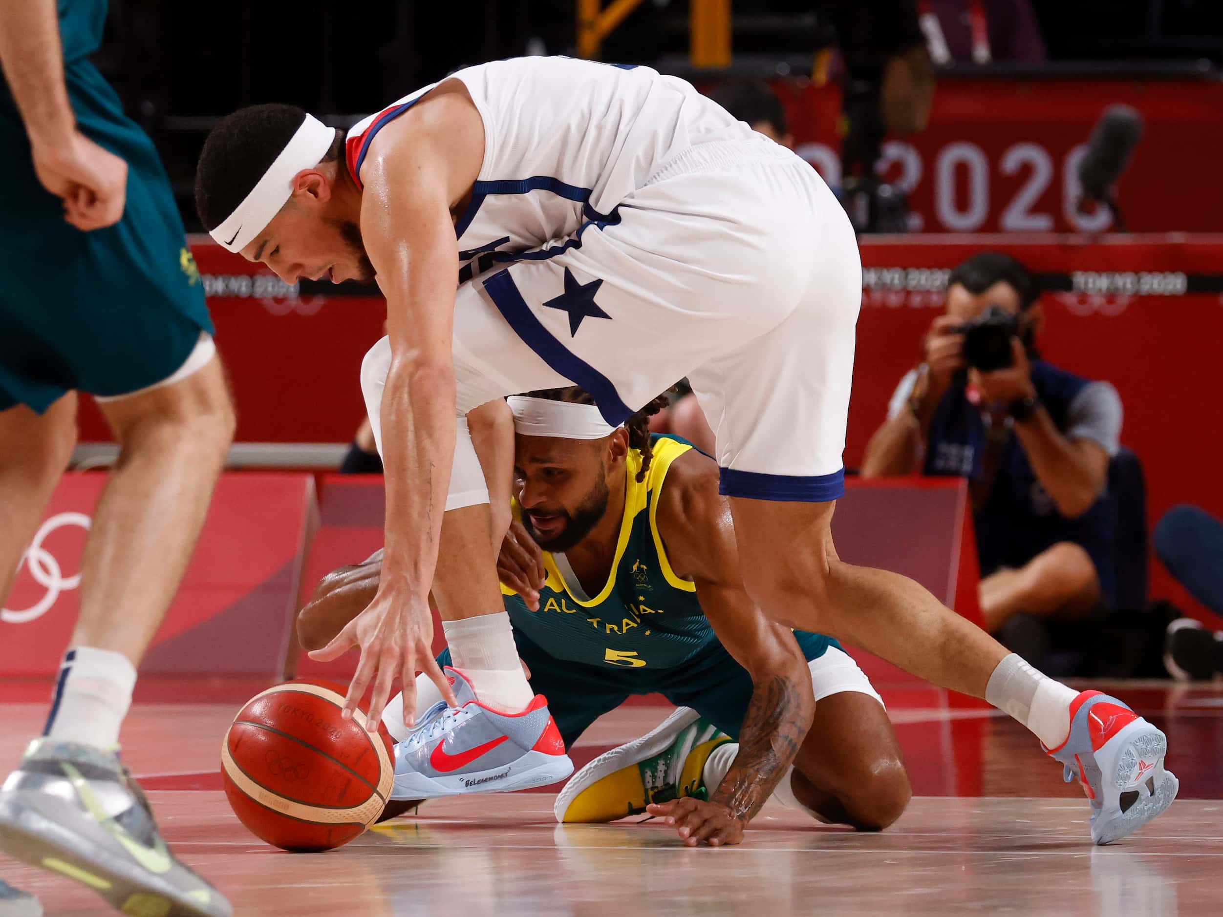 USA’s Devin Booker (15) and Australia’s Patty Mills (5) go after a loose ball during the...