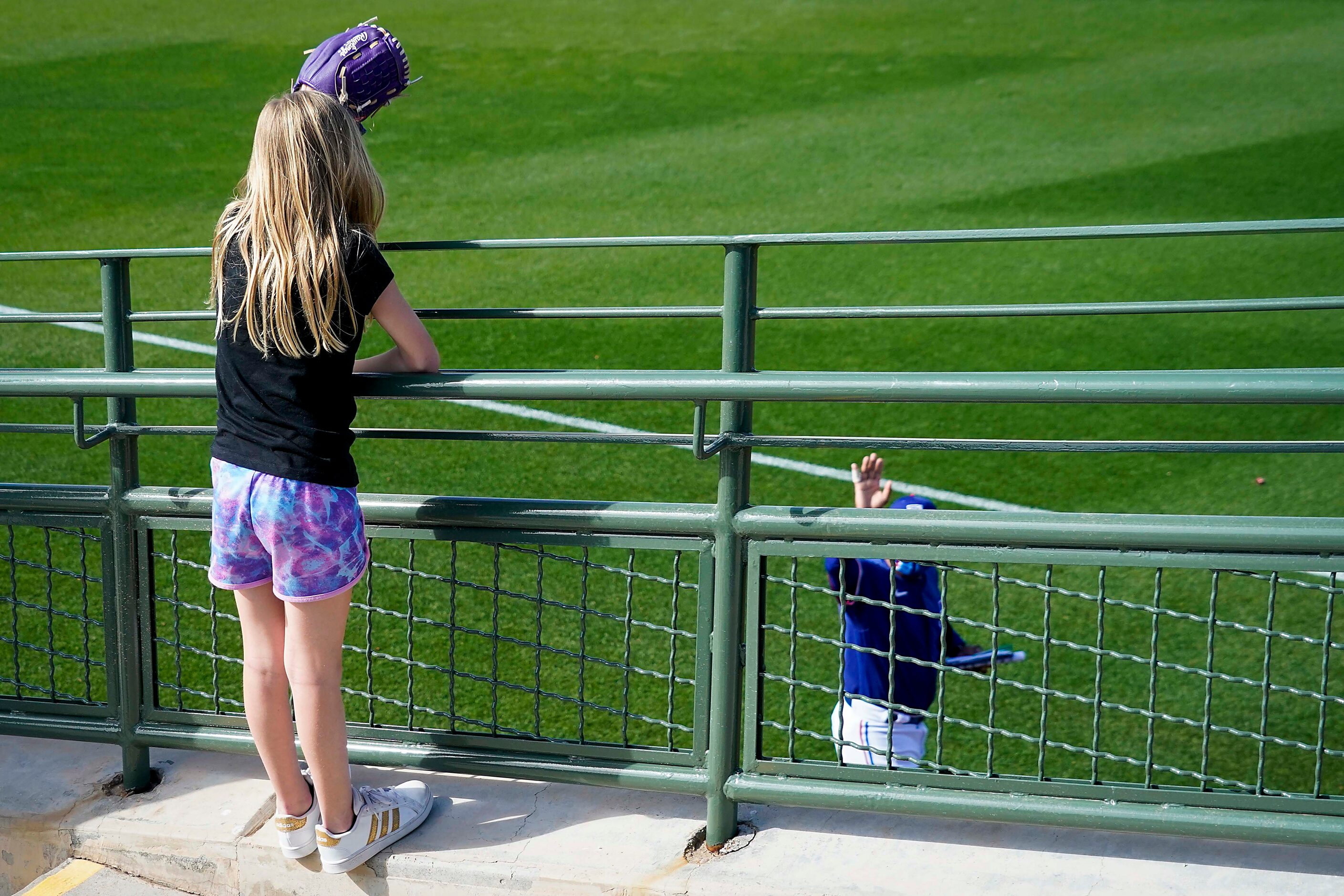 Texas Rangers third base coach Tony Beasley waves to a fan as he leaves the field following...