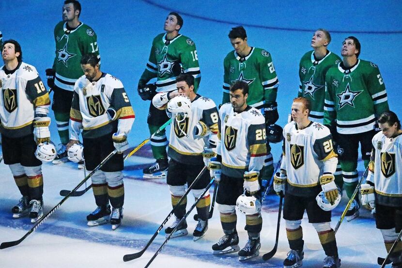 The Dallas Stars team takes up a position behind the Vegas Golden Nights team as a show of...