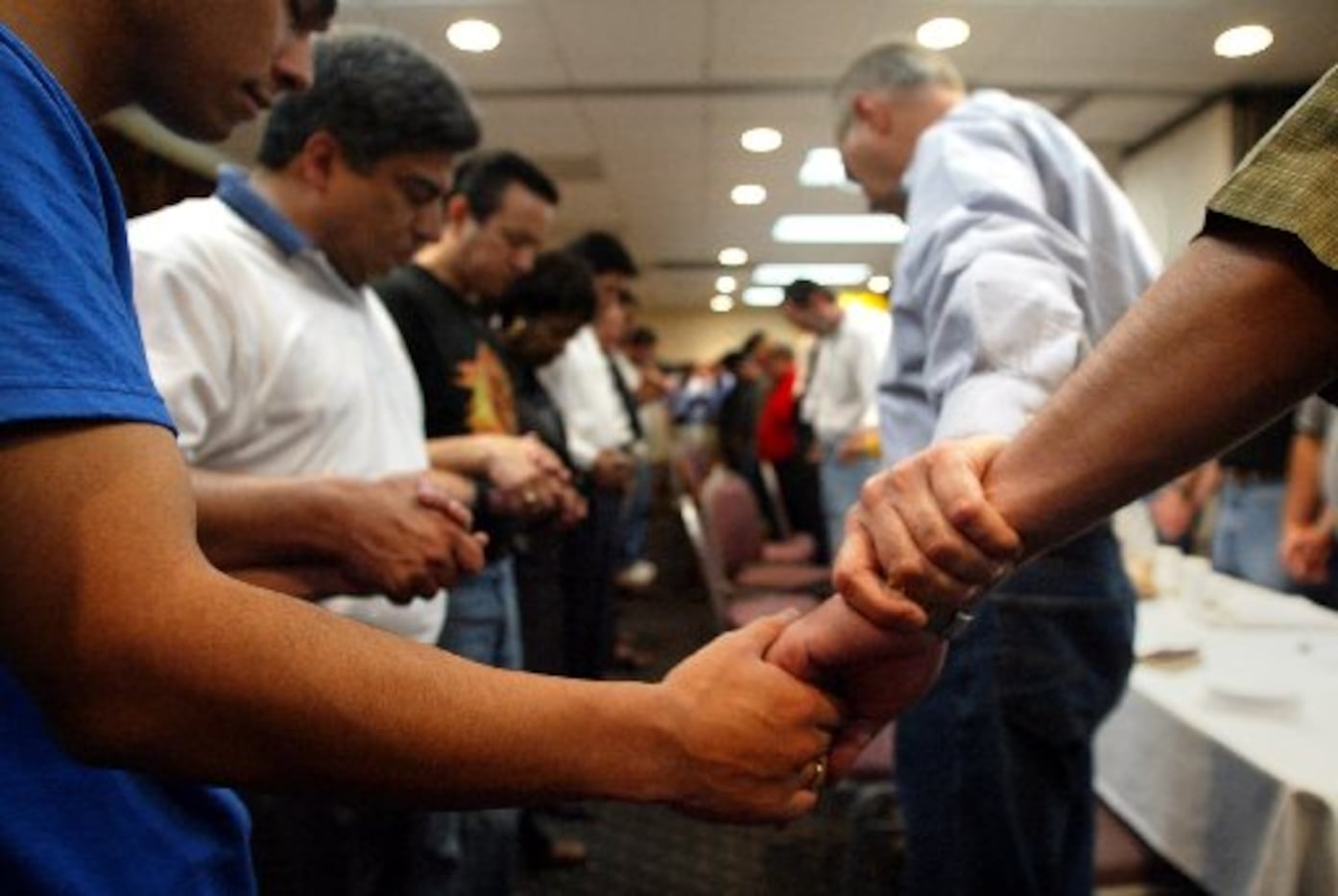Texas state Democratic representatives held hands in prayer to open their morning session in...