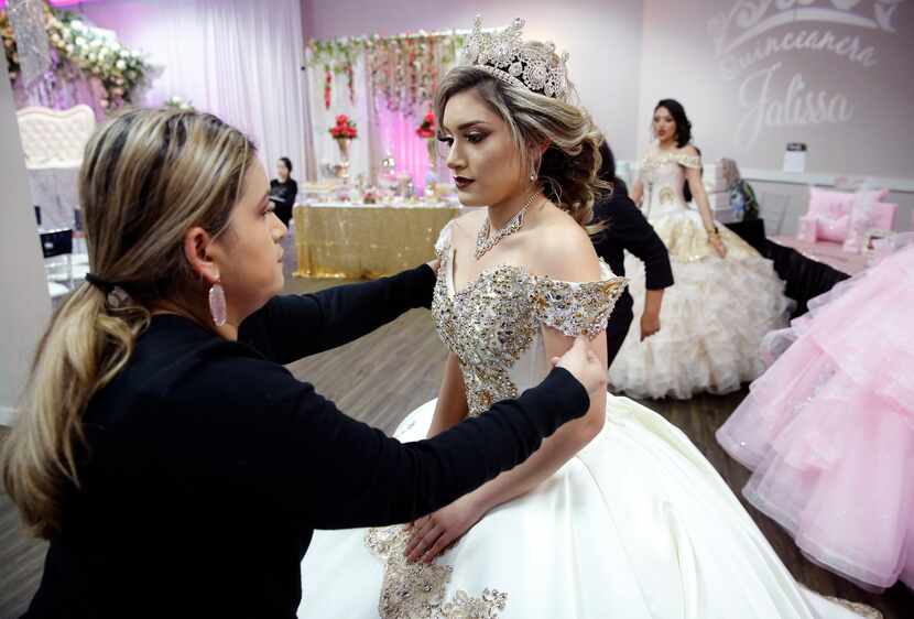 Ana Garcia fixes a quinceañera dress modeled by daughter Jessica Monge during the Las Lomas...