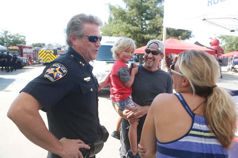 
New Rockwall Police Chief Kirk Riggs, visits with  Keith Powell, his son Max Powell, 4, and...