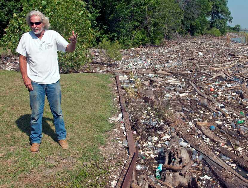 
Chuck Slater stands near the trash and debris that collects near his home on Lake Ray...