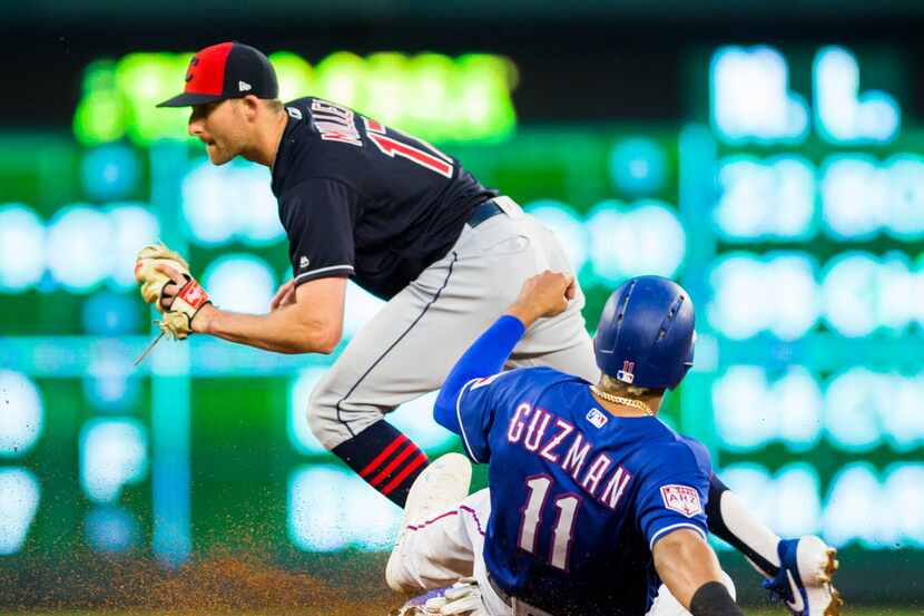 Texas Rangers first baseman Ronald Guzman (11) is out at third base with a catch by...