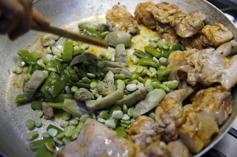 Add broad beans and artichoke hearts to the chicken and rabbit.