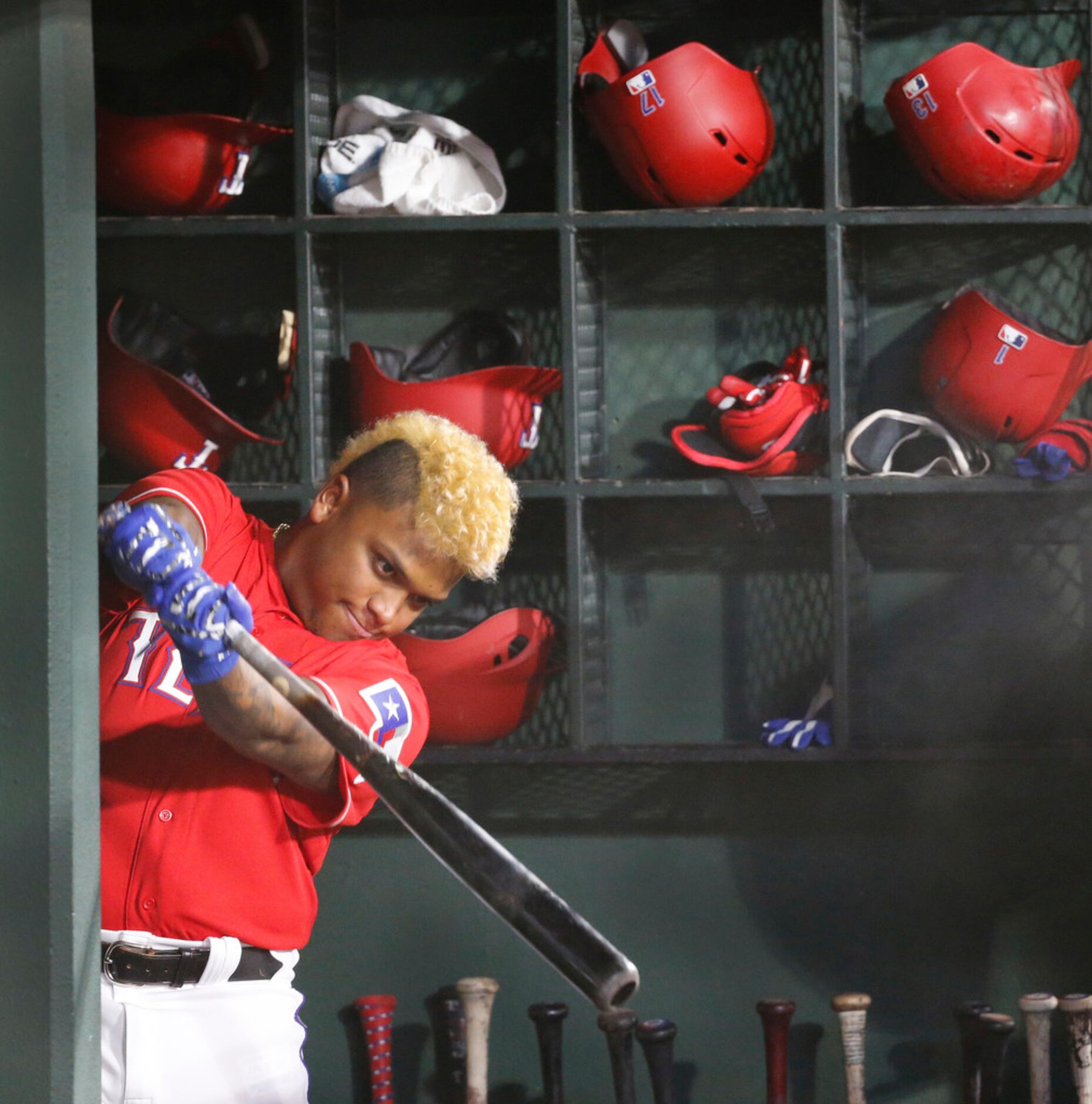 Texas Rangers designated hitter Willie Calhoun (5) waits for an at bat in the dugout in the...