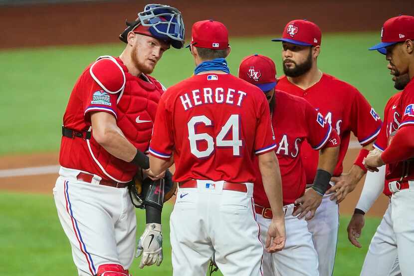 FILE - Rangers reliever Jimmy Herget gets a visit from catcher Sam Huff, second baseman...