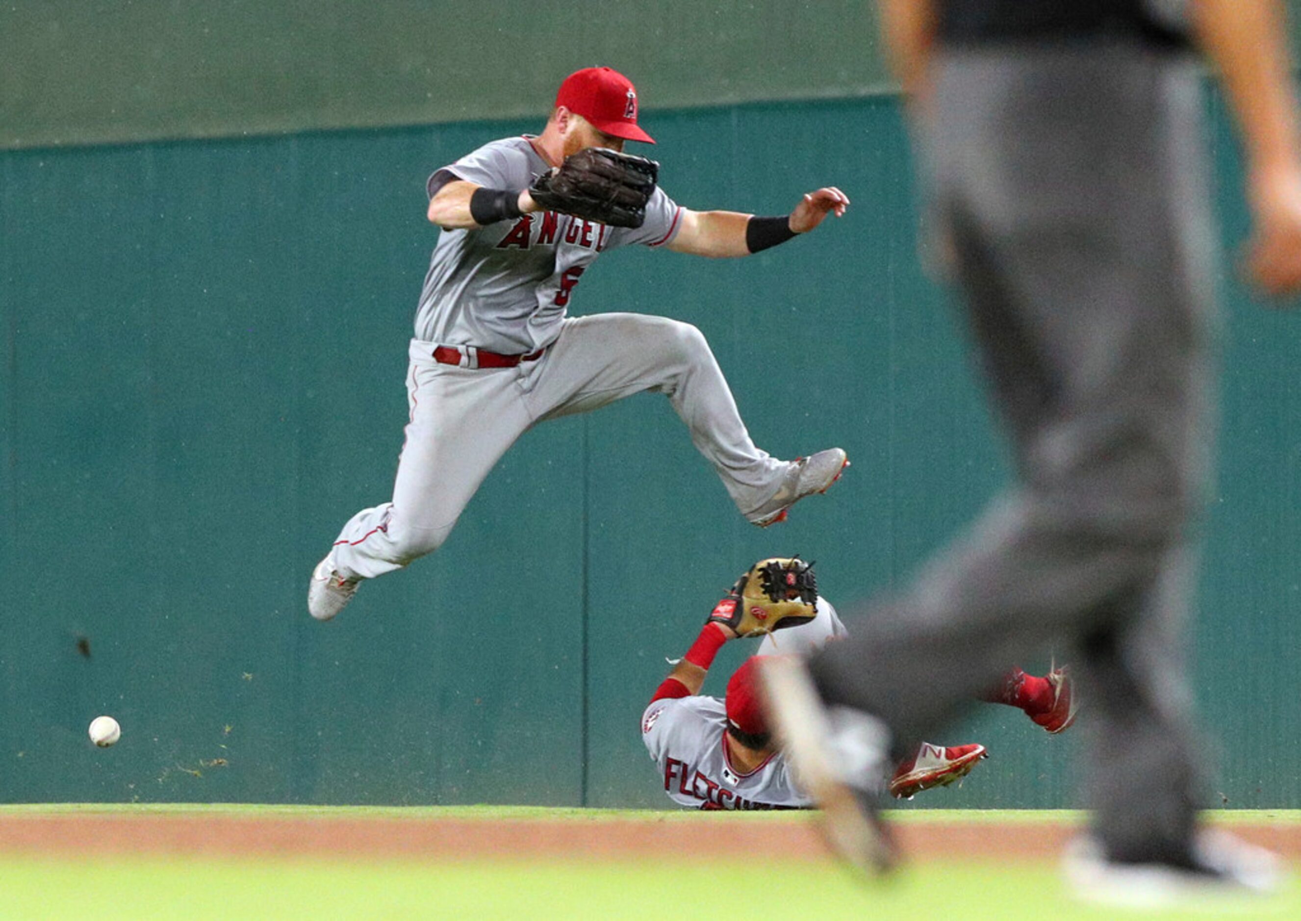 Los Angeles Angels right fielder Kole Calhoun (56) leaps to avoid colliding with second...