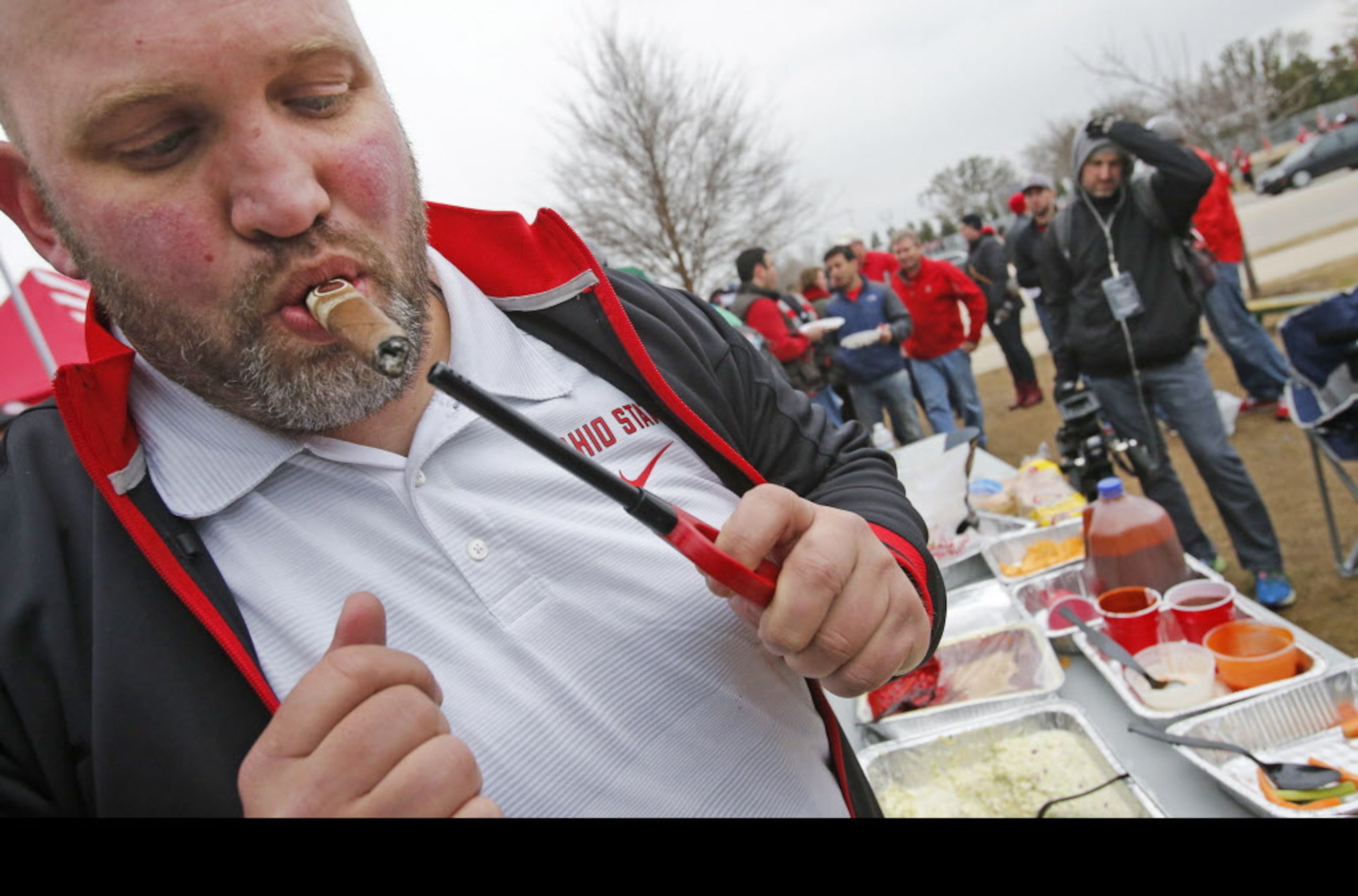 Nick Meiser from Canton, Ohio lights up a stogie as he tailgate with friends before the...