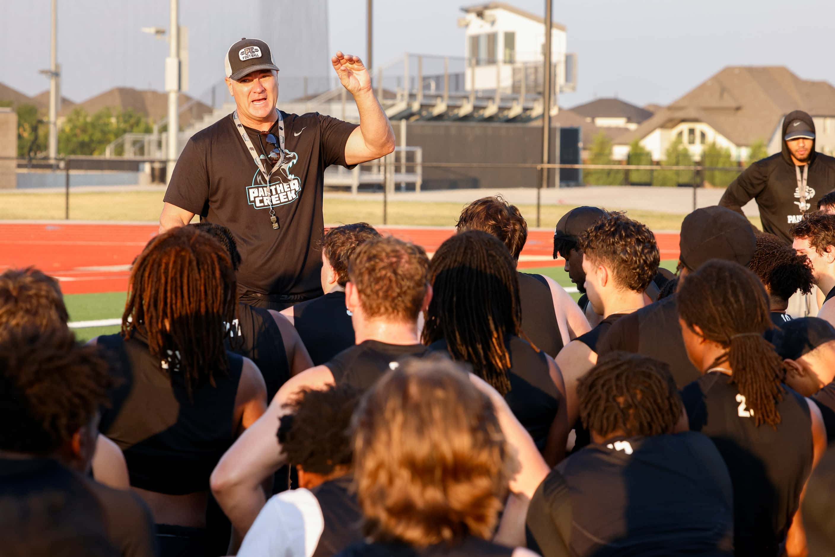 Head football coach Clint Surratt talks to players after the first day of practice at...