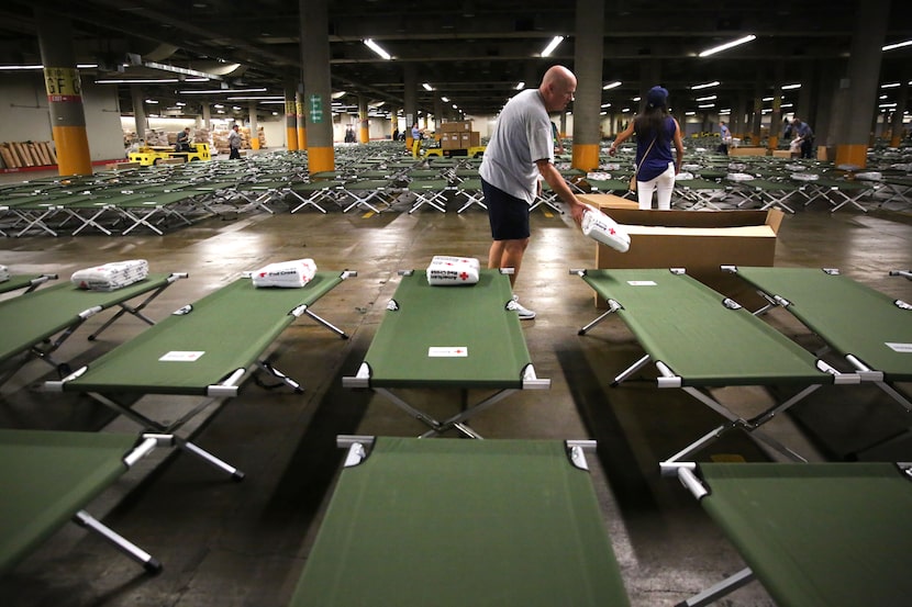 Volunteer Rick Gilbert distributes American Red Cross blankets inside the "mega shelter" at...