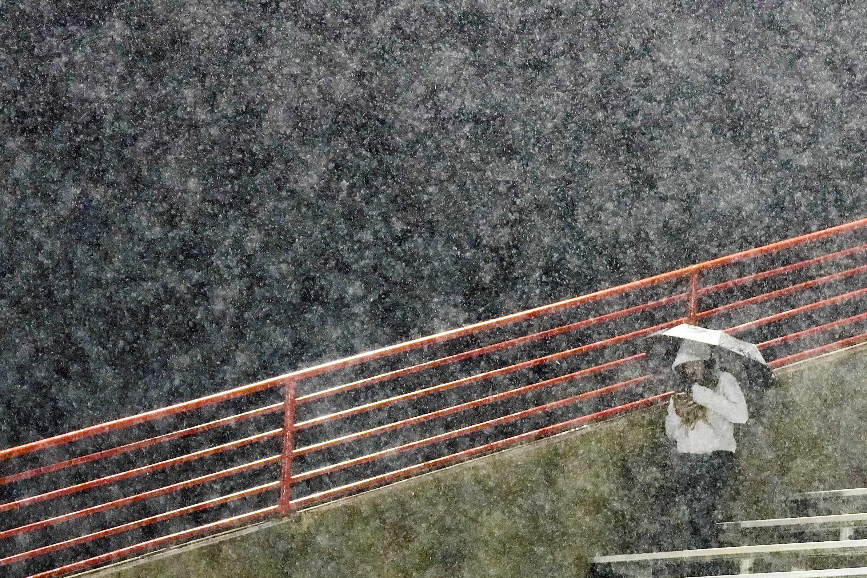 Duncanville fans take cover from a heavy rain before a District 11-6A high school football...