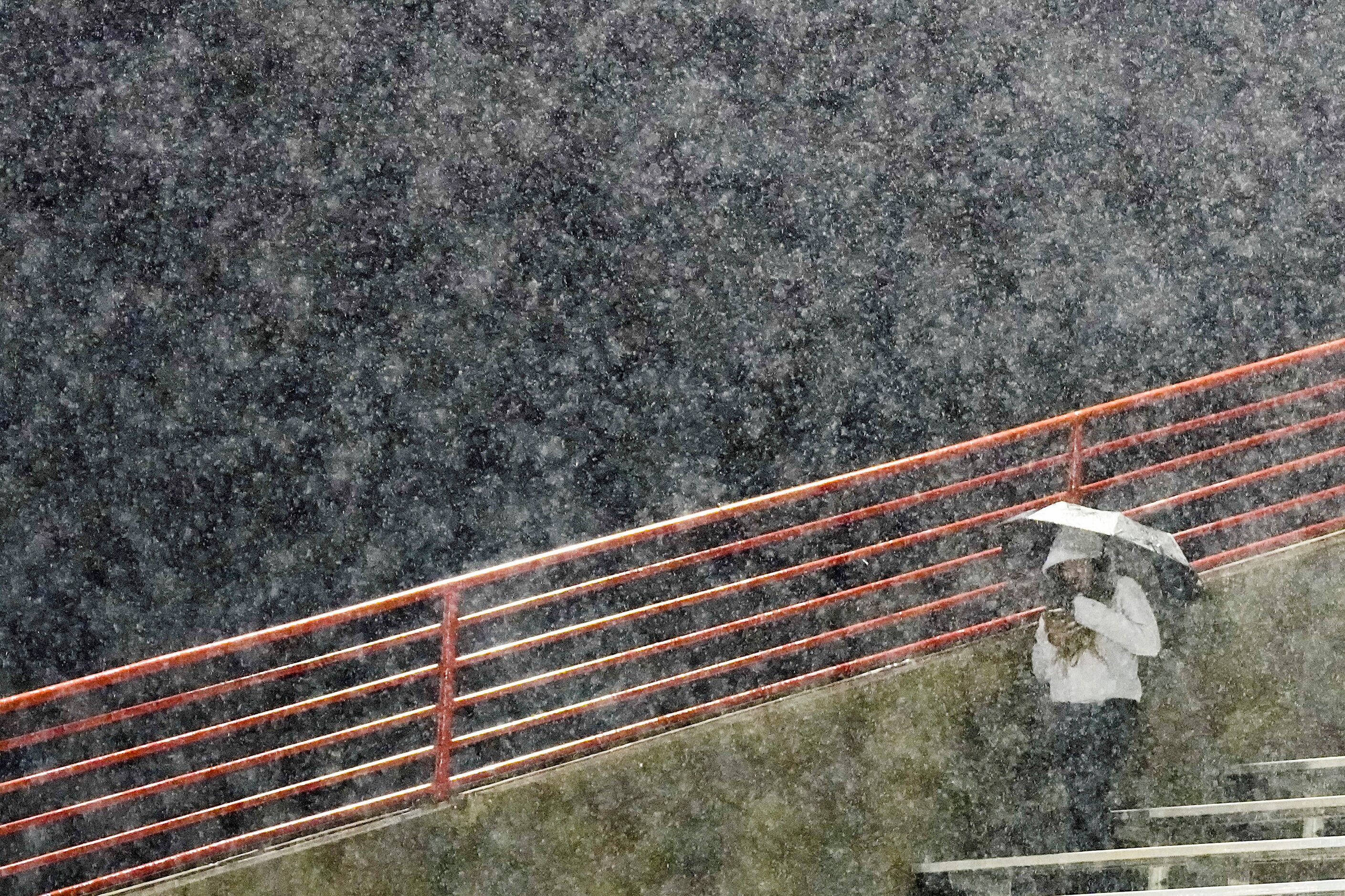 Duncanville fans take cover from a heavy rain before a District 11-6A high school football...