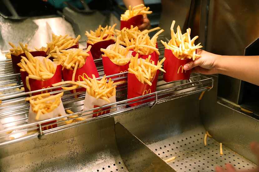 McDonald's crew member Samantha Medina prepares french fries at a the McDonald's restaurant...