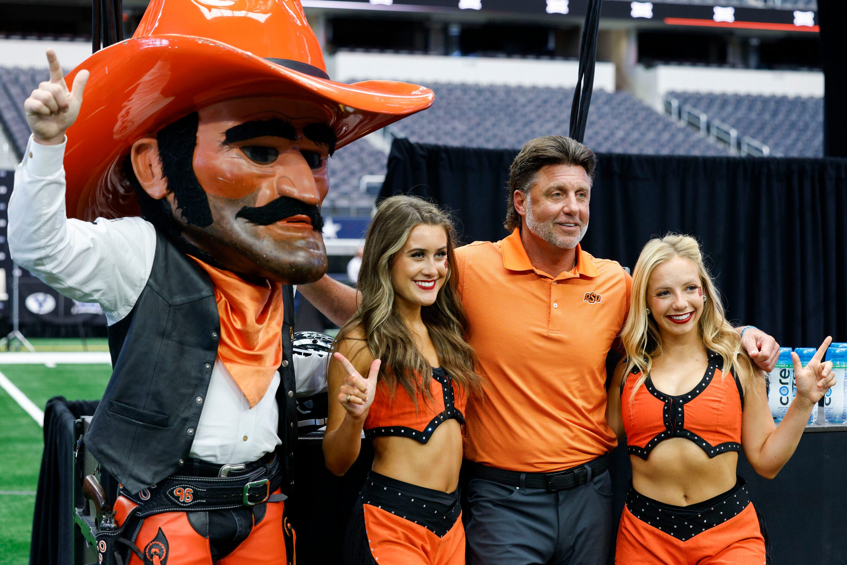 Oklahoma State head coach Mike Gundy poses for a photo with cheerleaders and mascot during...