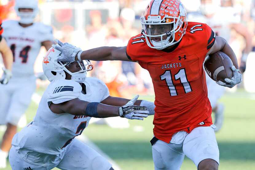 Rockwall High School wide receiver Jaxon Smith (11) puts a stiff arm on Sachse High School...