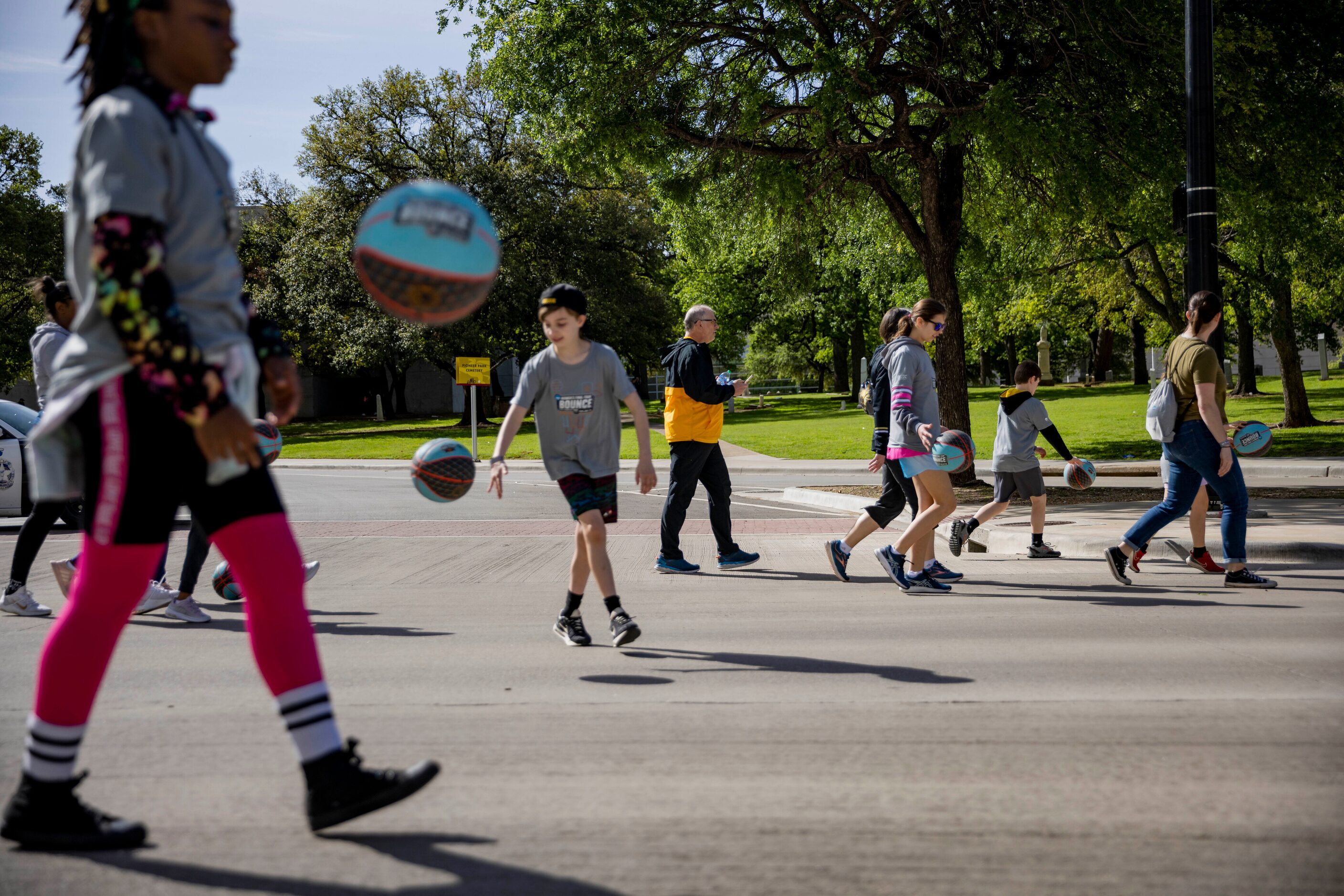 People dribble basketballs from City Hall to Tourney Town at the Kay Bailey Hutchison...