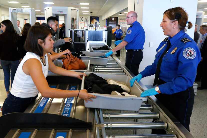 TSA officers Julie Alzaitoun (right) and Dennis Selzer (center) helps passengers at the new...