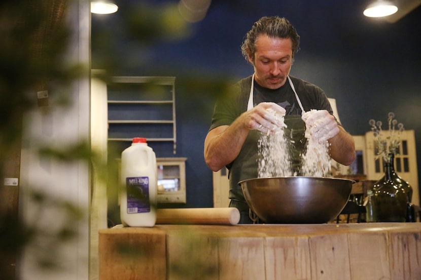 Chef Robert Lyford combines ingredients while preparing cheddar biscuits at Patina Green...