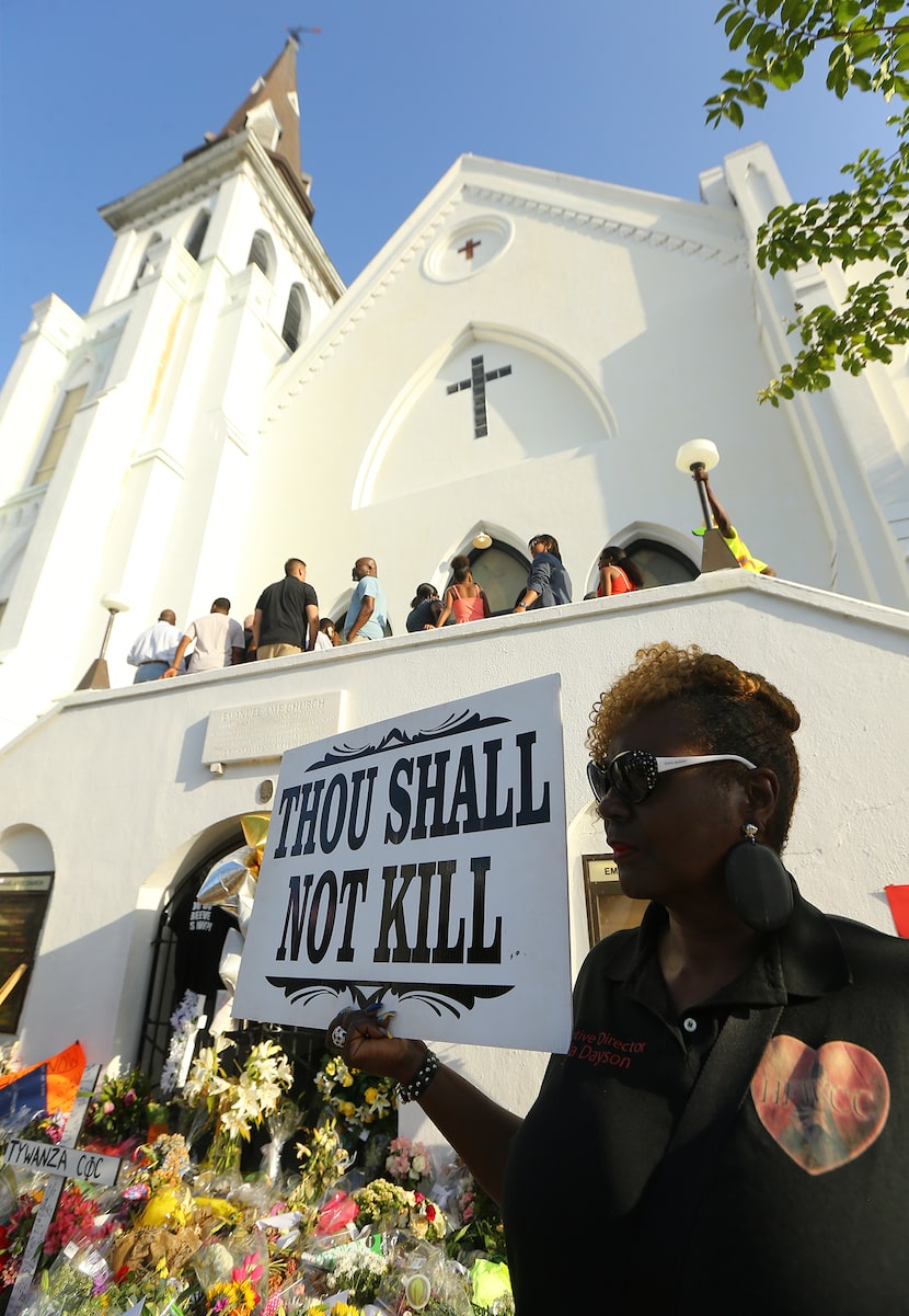 Linda Dayson holds a sign as members of the public and church members enter the "Mother"...