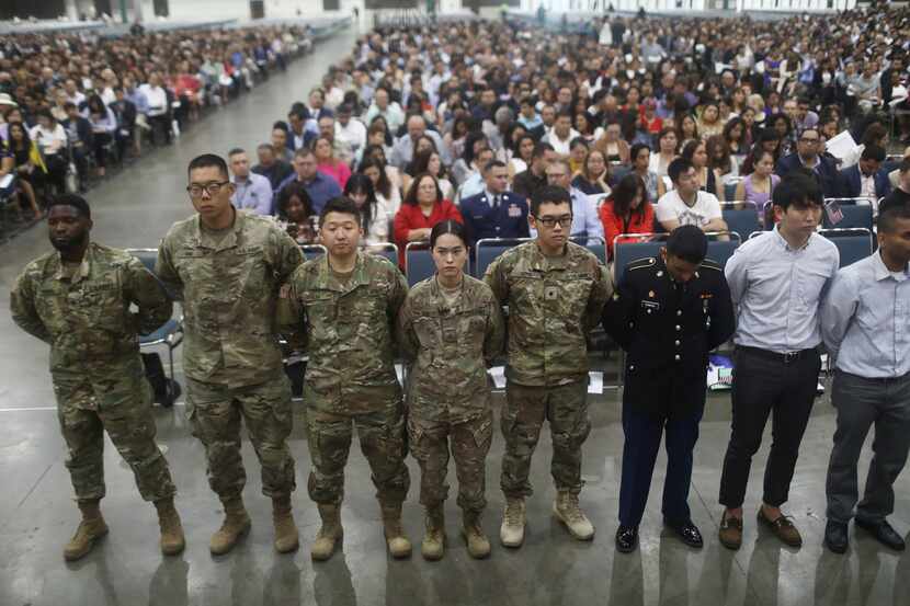 U.S. military members stand after becoming U.S. citizens at a naturalization ceremony on...