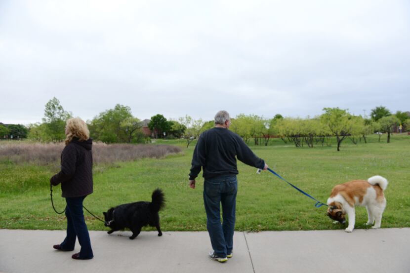 Travis and Jill Schriefer walk their dogs Princess and Lilly in Carrollton's Frankford...