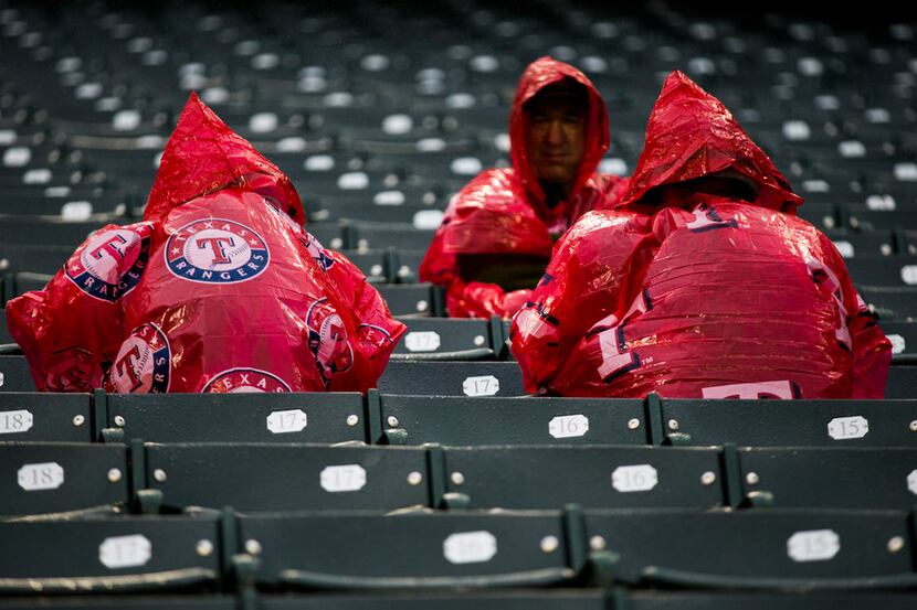 Texas Rangers fans wait in the rain before an MLB game between the Texas Rangers and the...