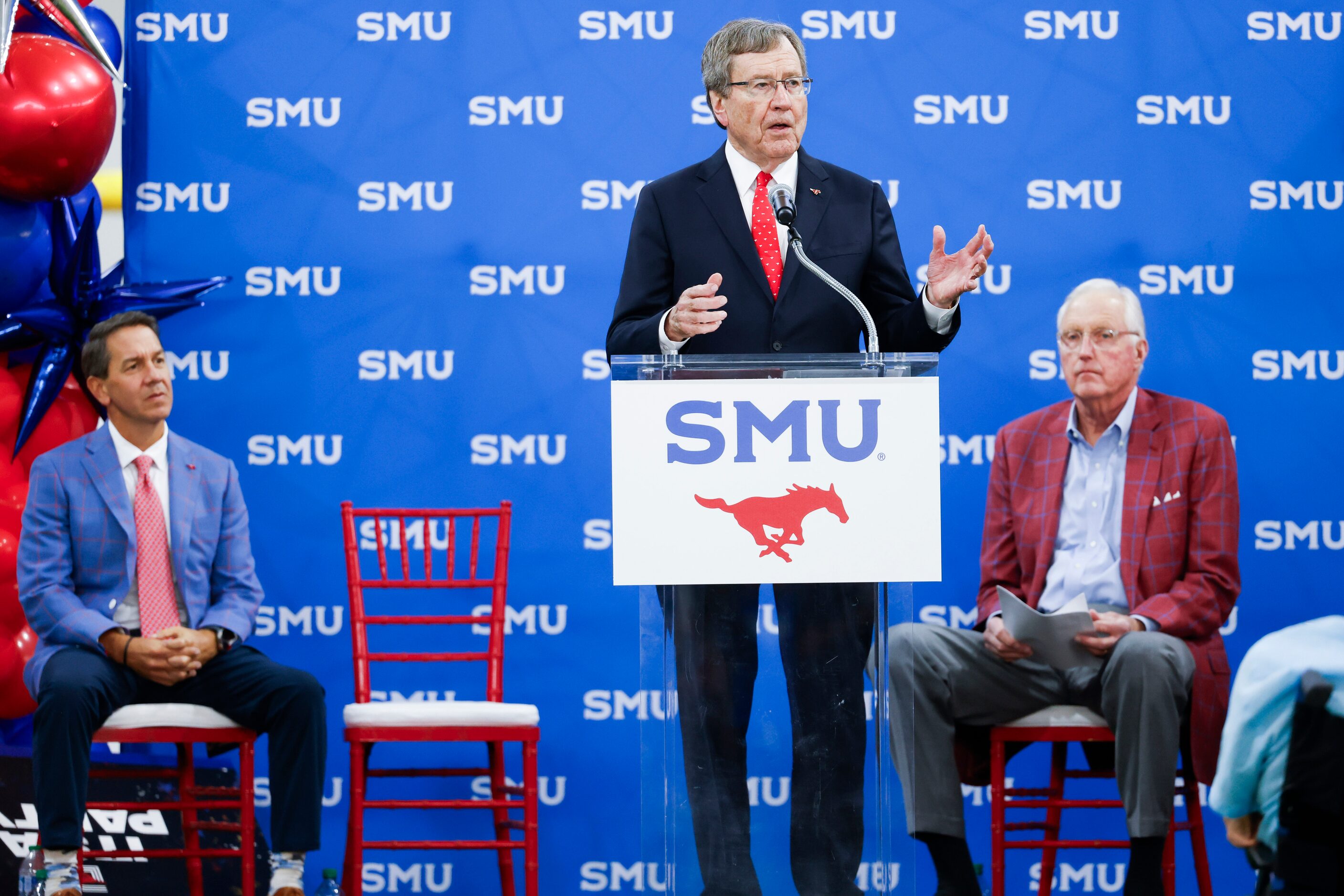 SMU director of athletics Rick Hart (left) and board chair David Miller (right) listen to...