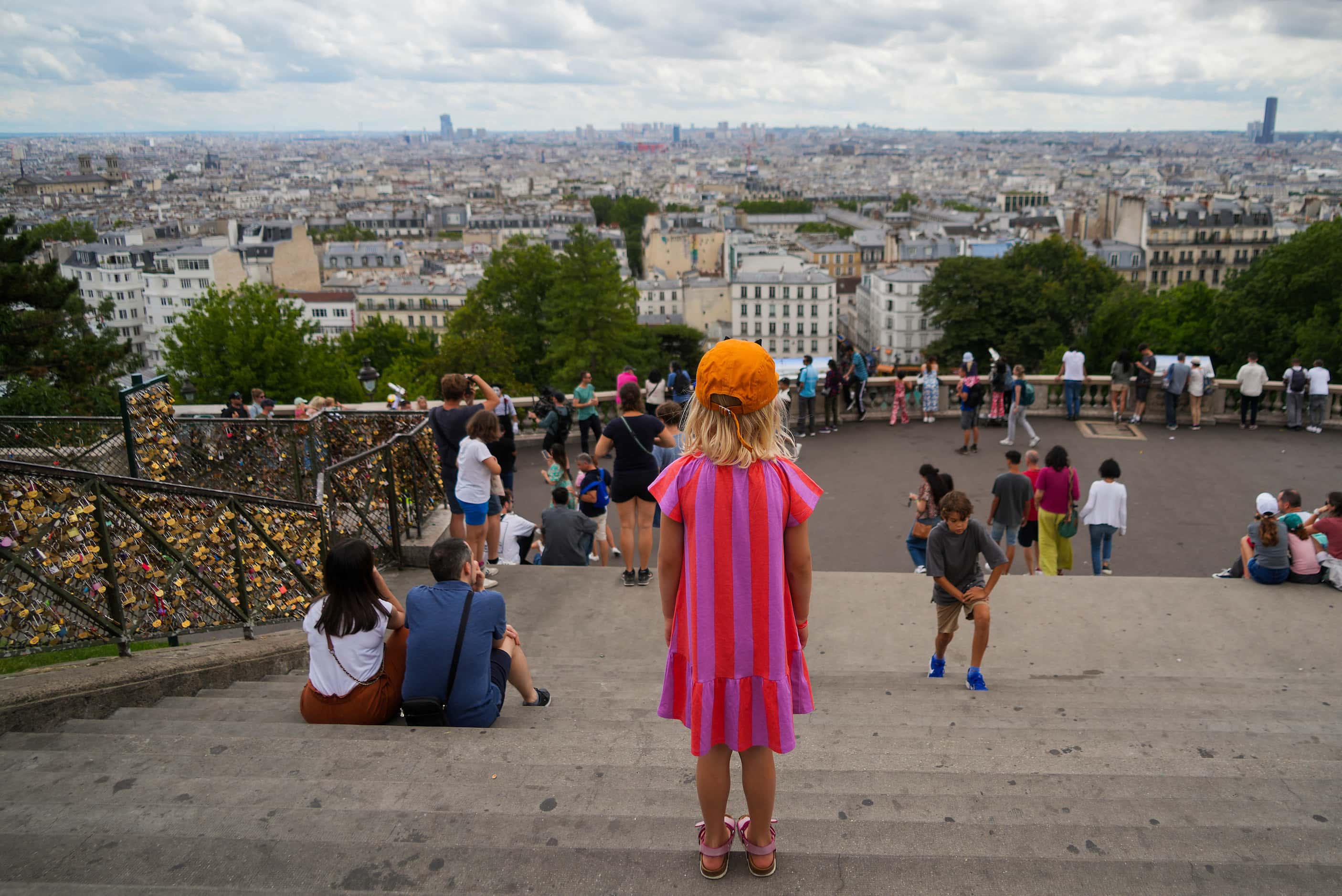 People look out over the city from the step sof the Basilique du Sacré-Cœur de Montmartre...