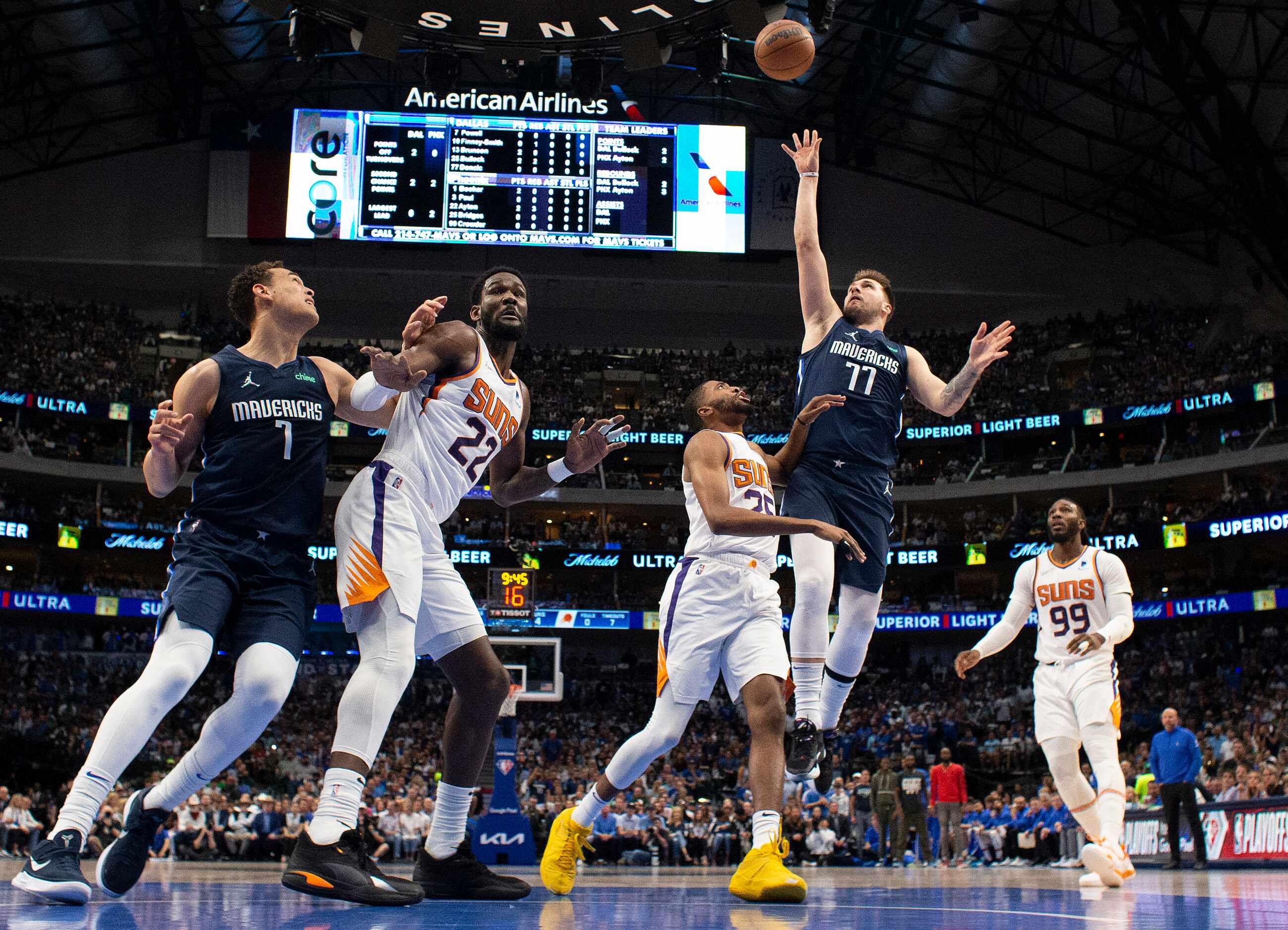 Dallas Mavericks guard Luka Doncic (77) puts up a first half shot over Phoenix Suns forward...