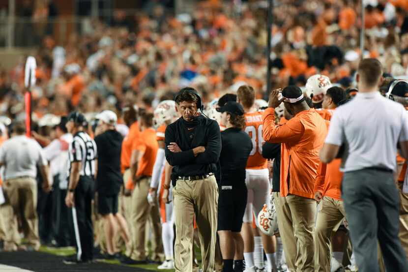 Oklahoma State head coach Mike Gundy walks down the sideline during an NCAA college football...