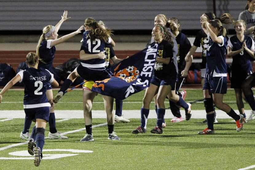 Sachse High Kayla McKeon (12) and Marissa Norman (2) and the rest of the team celebrate...