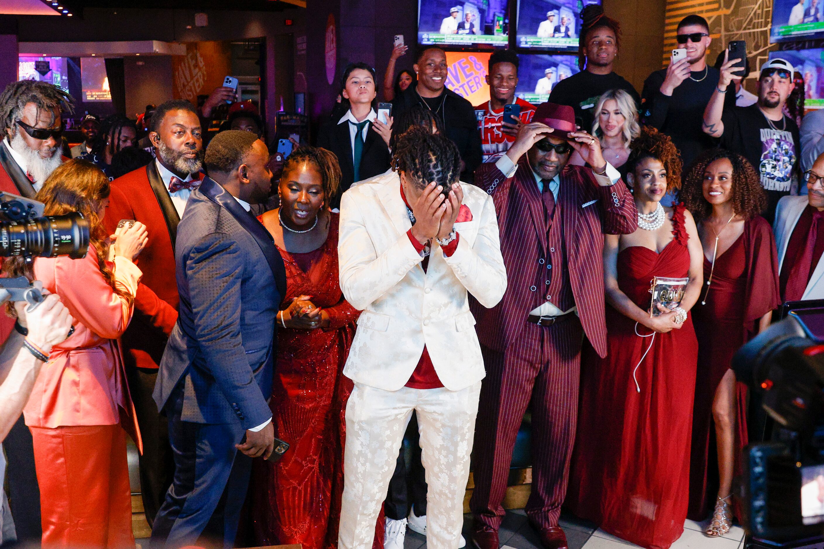 TCU wide receiver Quentin Johnston surrounded by family and friends gathers himself before...