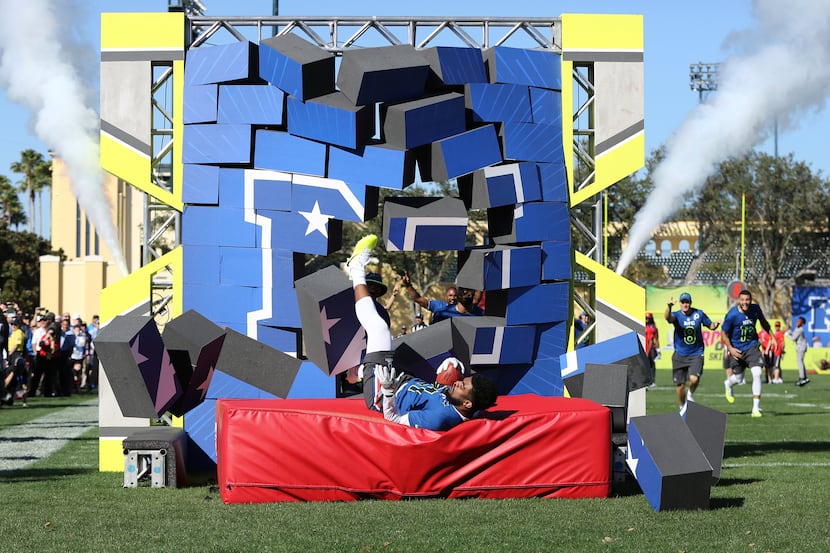 Dallas Cowboys Ezekiel Elliott (21) breaks through a wall for the Power Relay event at the...