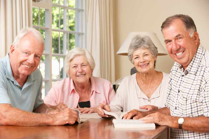 Four older people reading and smiling.