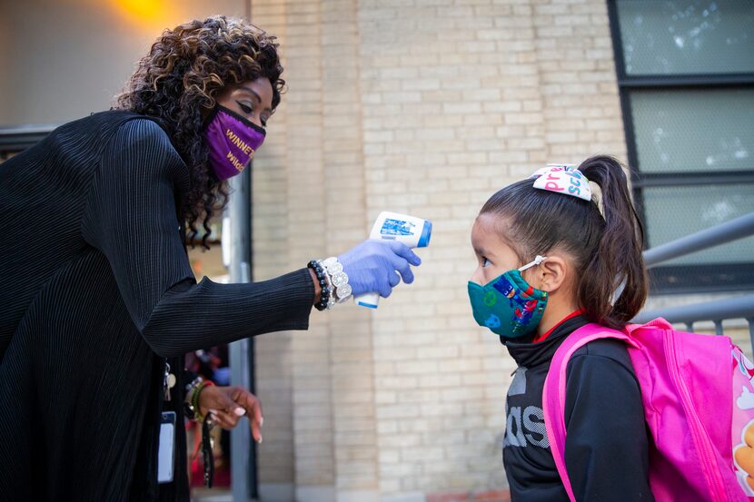 Assistant principal Clara Daniels checked Riley Pereyda’s temperature at Winnetka Elementary...