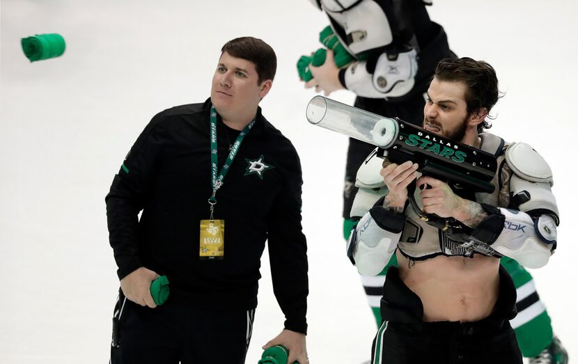 A Dallas Stars employee, left, watches as center Tyler Seguin fires a t-shirt out of a...