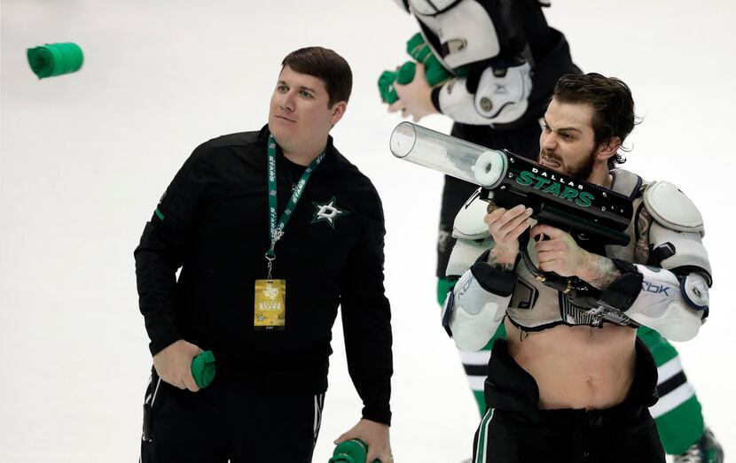 A Dallas Stars employee, left, watches as center Tyler Seguin fires a t-shirt out of a...